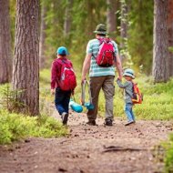 Father and boys going camping with tent in nature