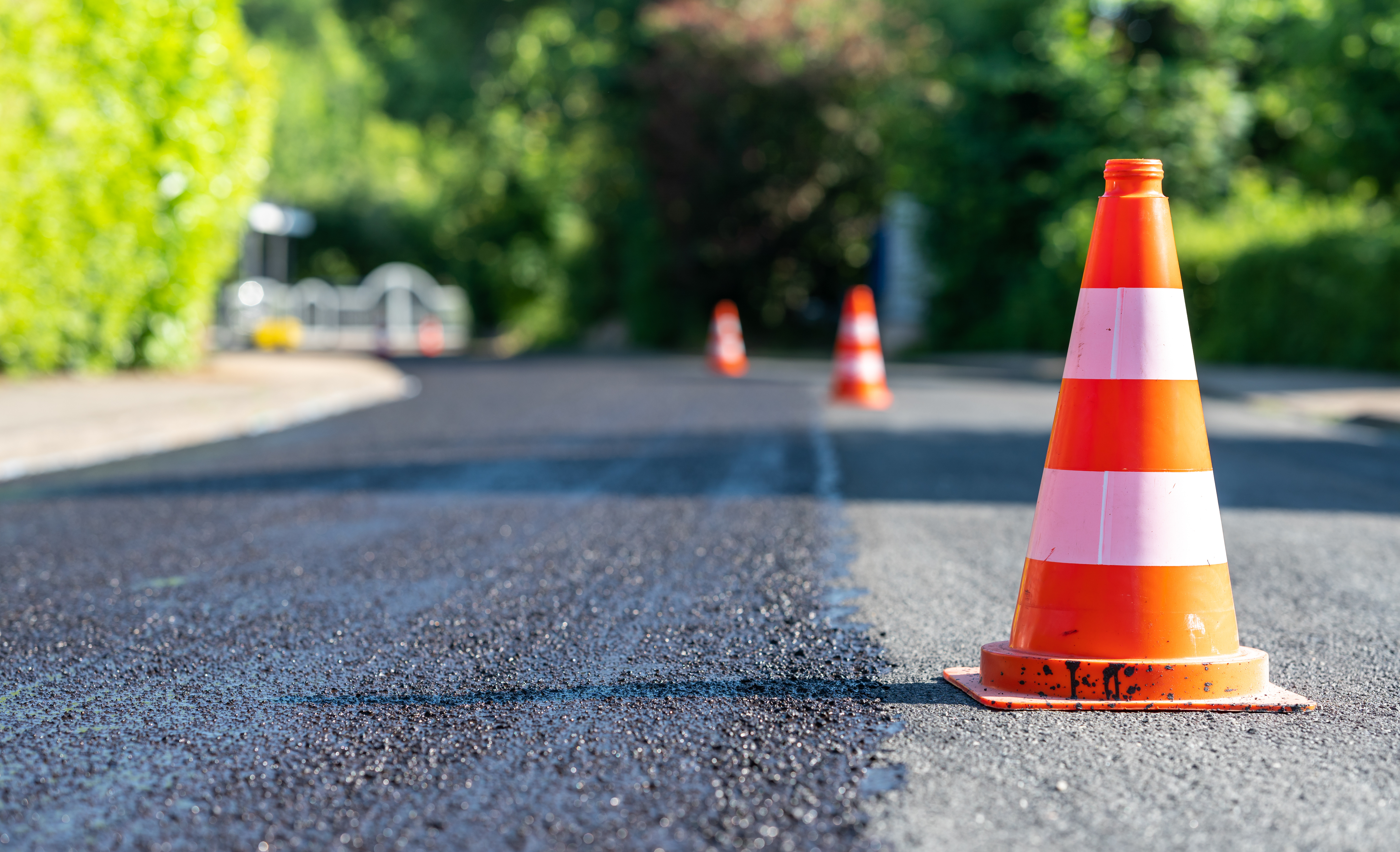 Construction cones marking part of road with a layer of fresh as