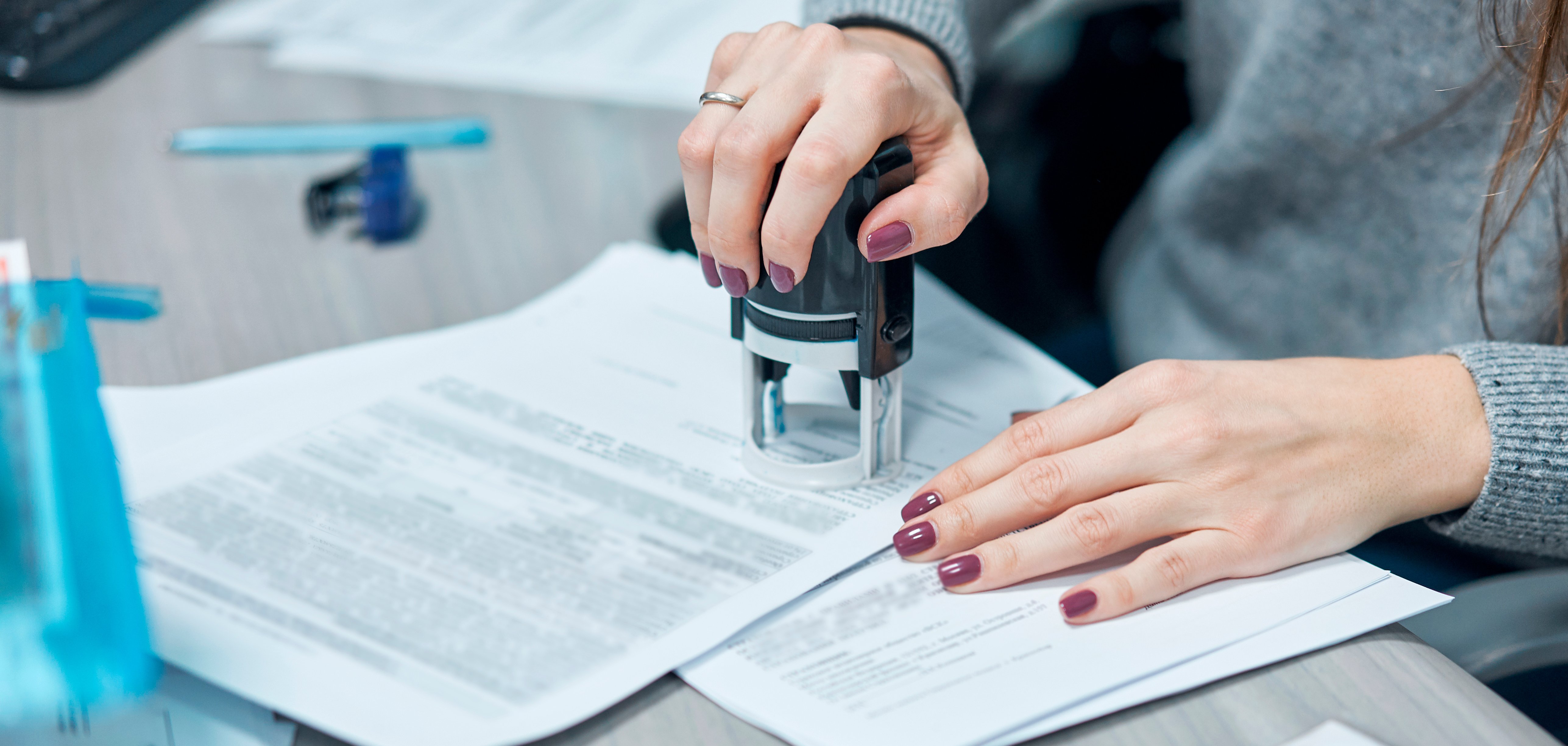 girl puts a stamp on documents in the office
