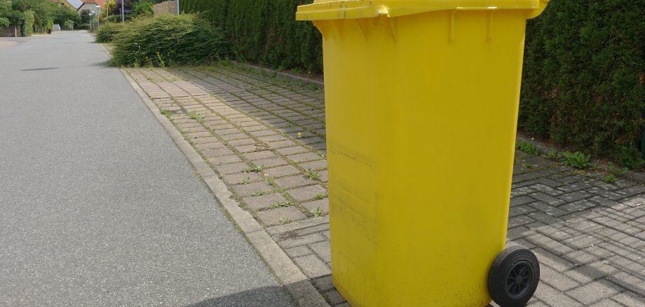 Yellow recycling can out on the street for pick up in a German suburb.