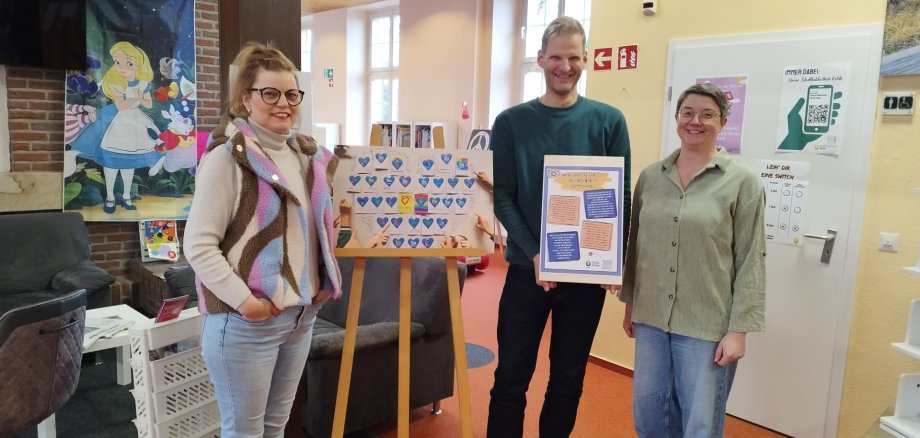 Stolz präsentieren Birgitt Wunderlich (Stadtbibliothek), Martin Werner und Magda Bender (beide Jugendamt) die Arbeiten die jungen Künster*innen.
