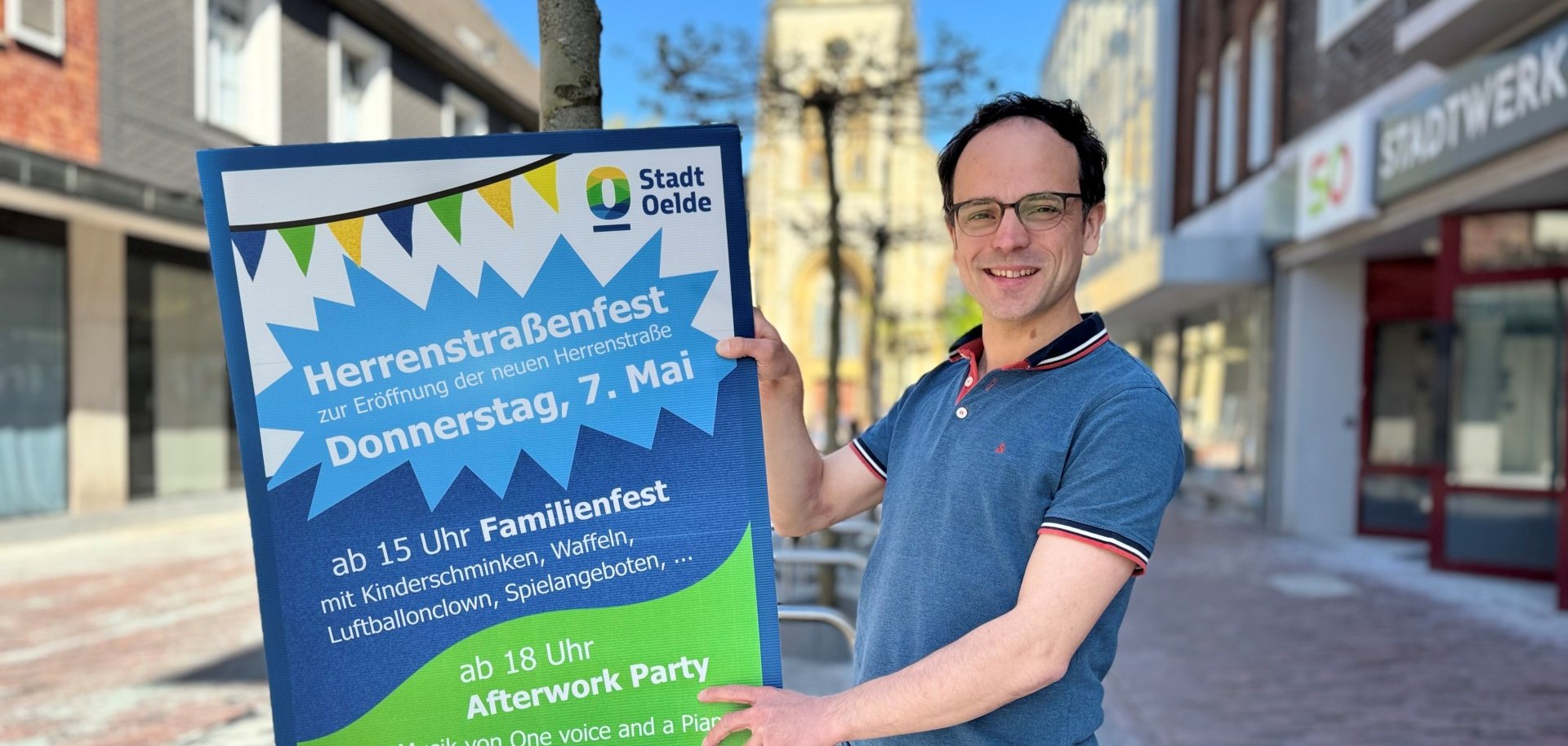 Das Bild zeigt Matthias Gernhardt vom Citymanagement mit einem Plakat der Veranstaltung.