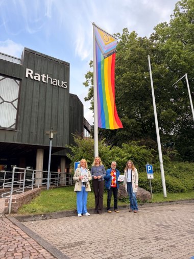 Personen vor Regenbogenflagge