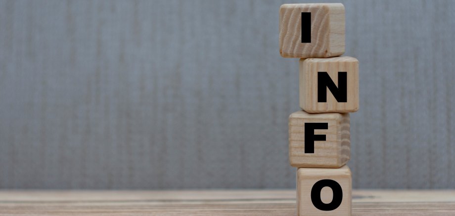 Information 4 Würfel mit der Aufschrift "Info" vor grauem Hintergrund