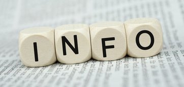 4 Würfel mit der Aufschrift "Info" auf einer Zeitung
