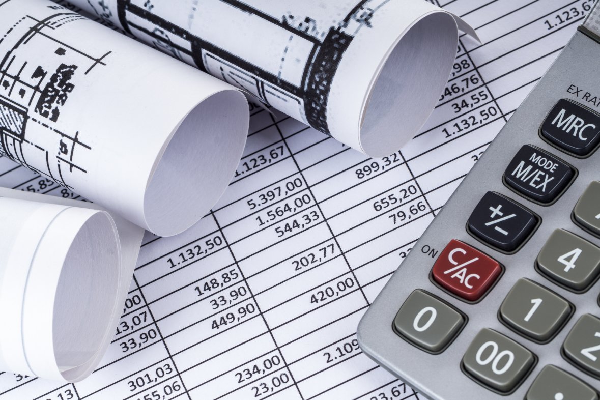 Taschenrechner und Baupläne auf einer Tabelle