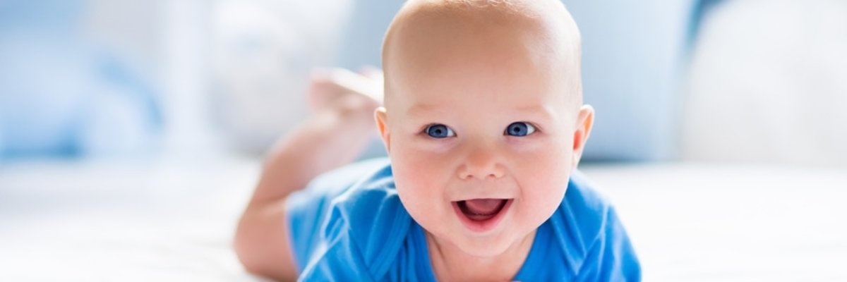 Baby boy in white sunny bedroom