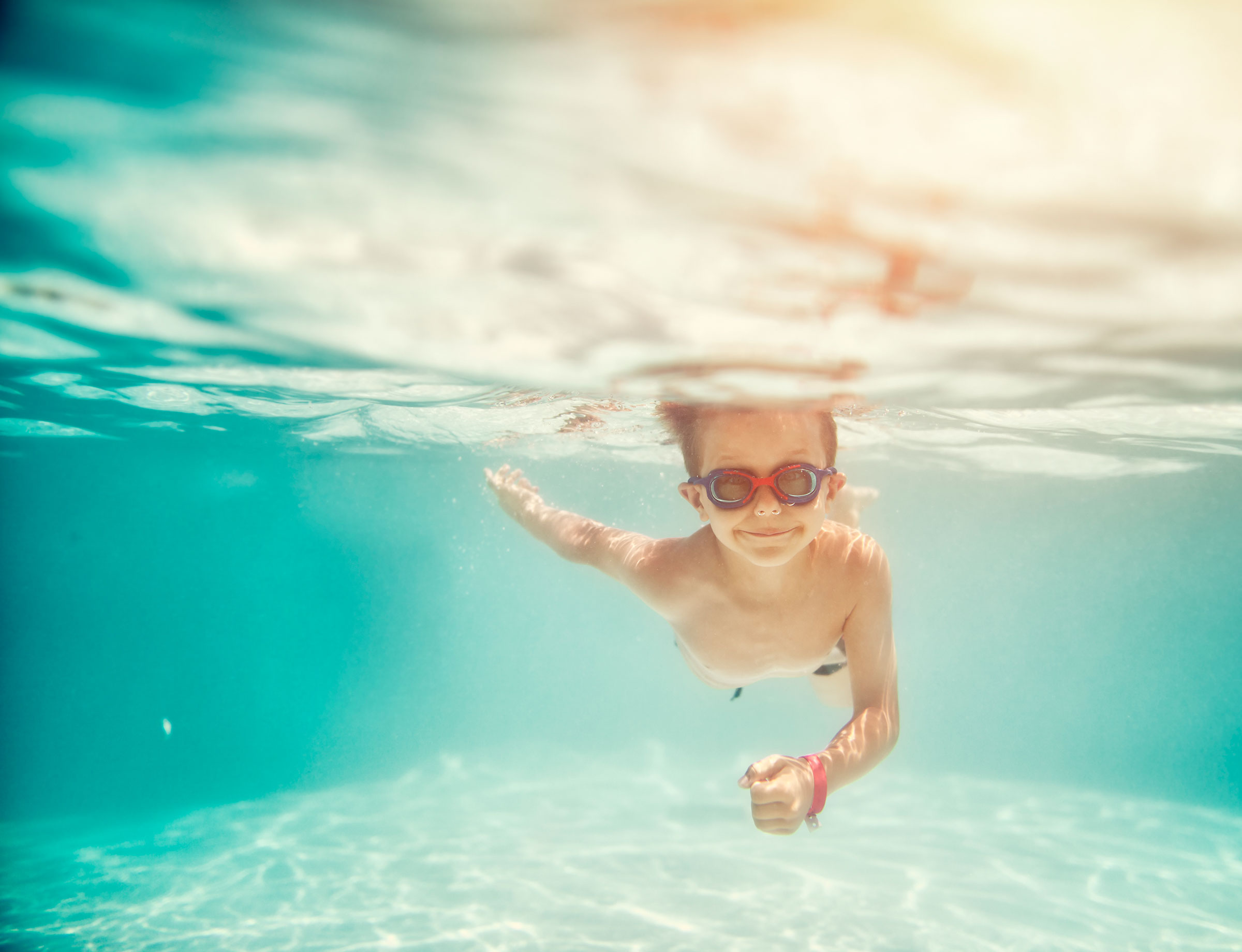 Kind schwimmt im Hallenbad