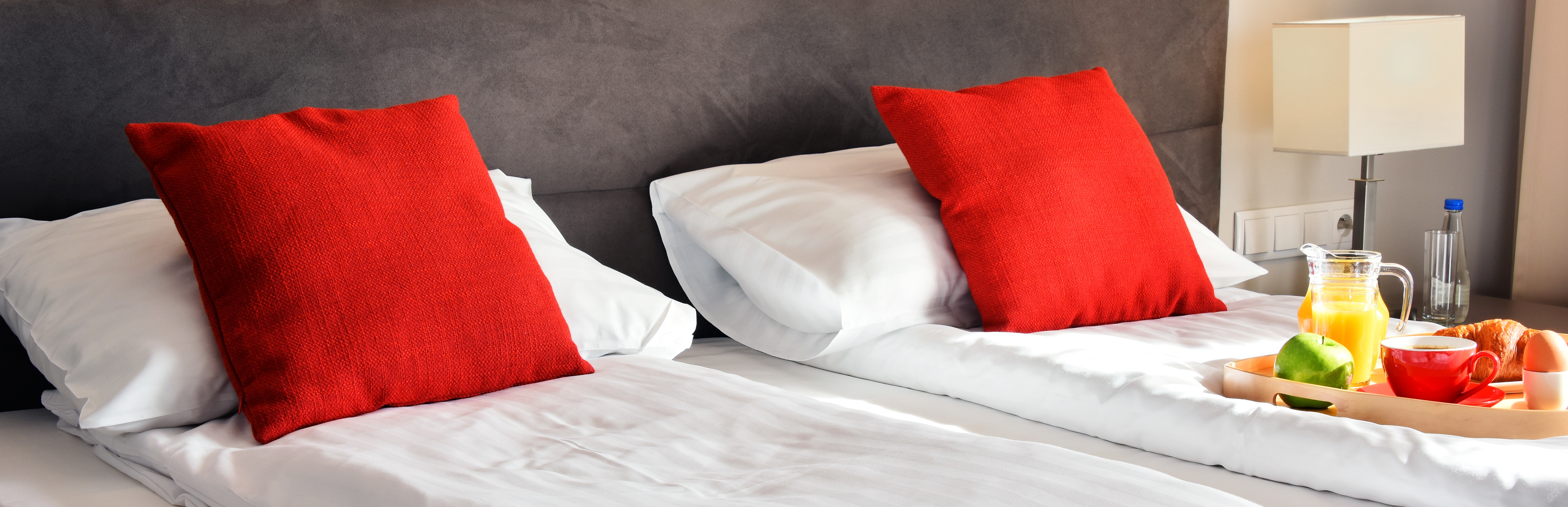 Breakfast on tray in bed in hotel room