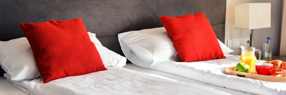 Breakfast on tray in bed in hotel room