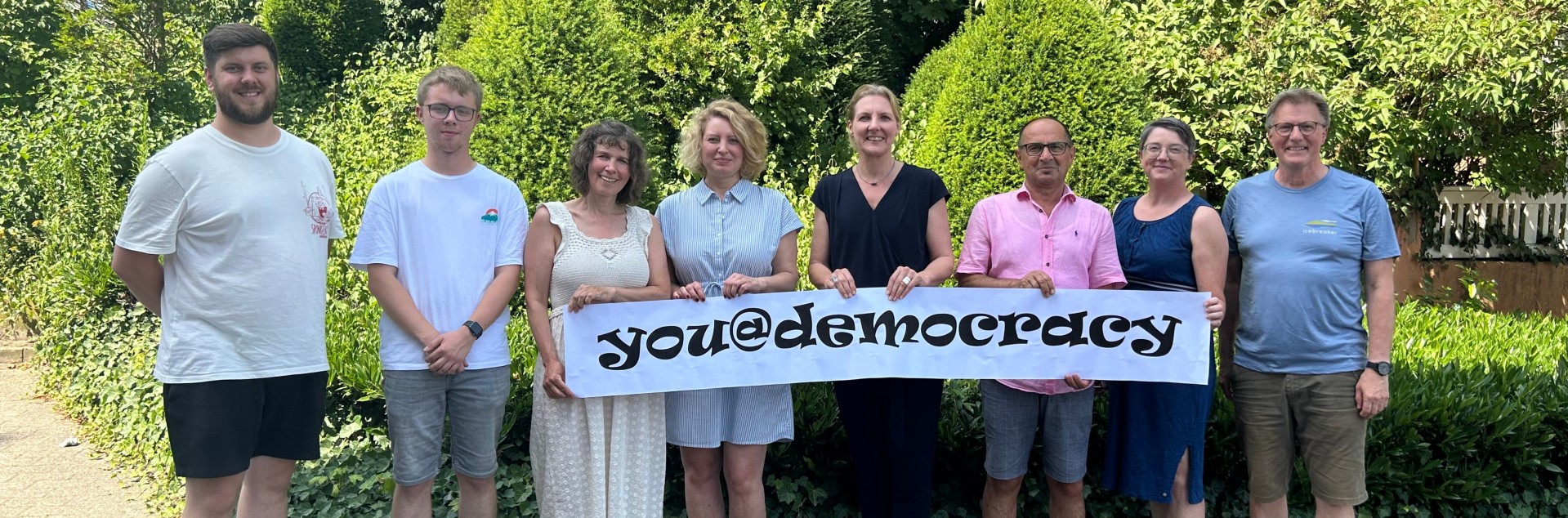 Bürgermeisterin Karin Rodeheger und Projektverantwortliche halten Banner mit der Aufschrift "you@democracy" hoch