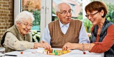Älteres Ehepaar und Tochter spielen ein Brettspiel