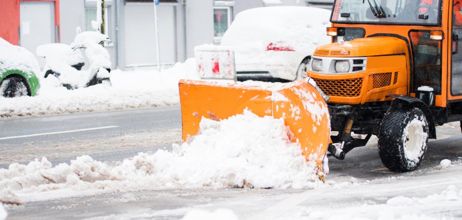 Schneepflug räumt die Straßen in der Stadt, Winterdienst