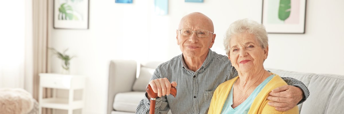 Elderly couple sitting on couch in living room Elderly couple sitting on couch in living room