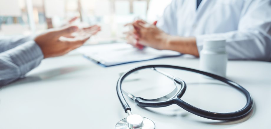 Doctors and patients consulting and diagnostic examining sit and talk. At the table near the window in the hospital medicine concept