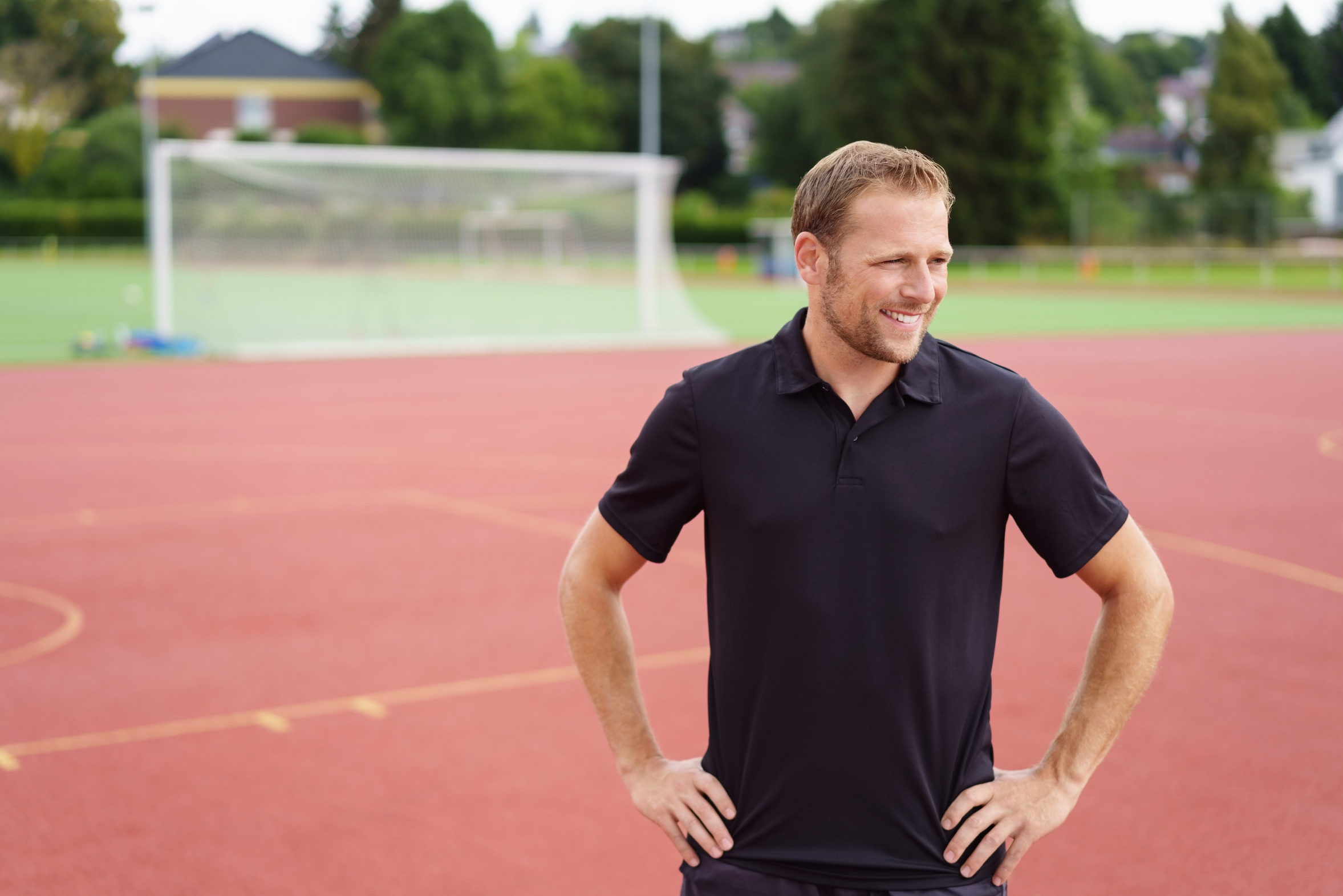 mann steht draußen auf einem sportplatz