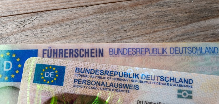 German ID card and driver’s license in hand, EU flag, Modern European driving permit, identification and travel, personal card and license, EU citizen travel, mobility documents