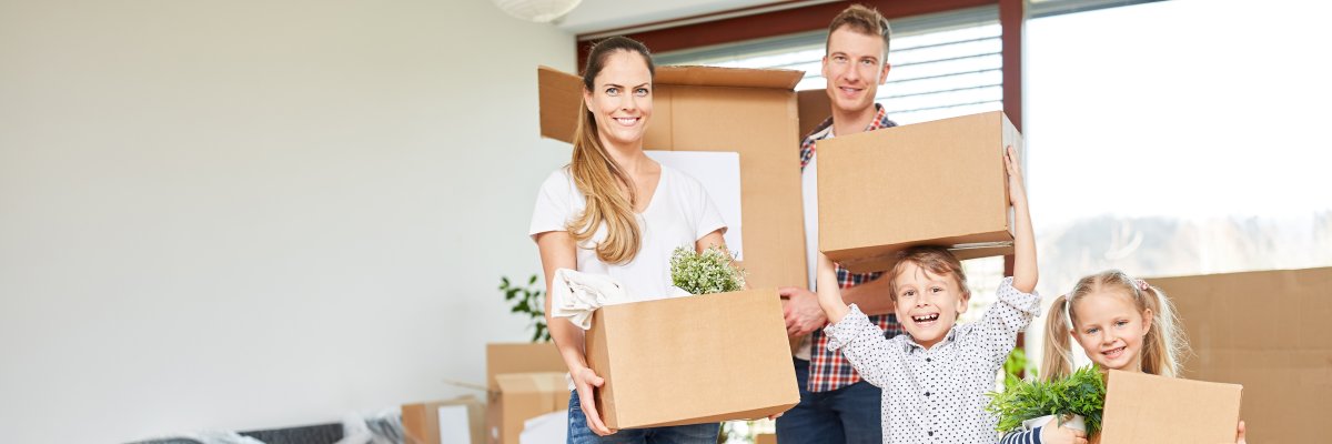 Eltern und Kinder tragen Umzugskartons