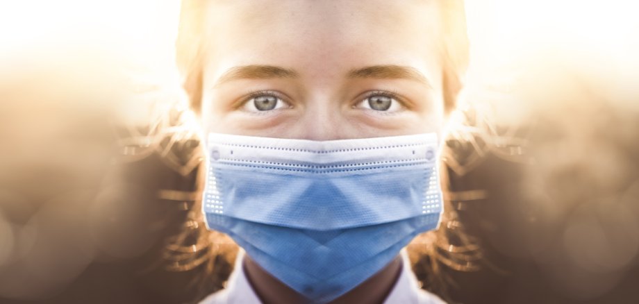 Woman wearing protective mask against coronavirus. Put mask to f