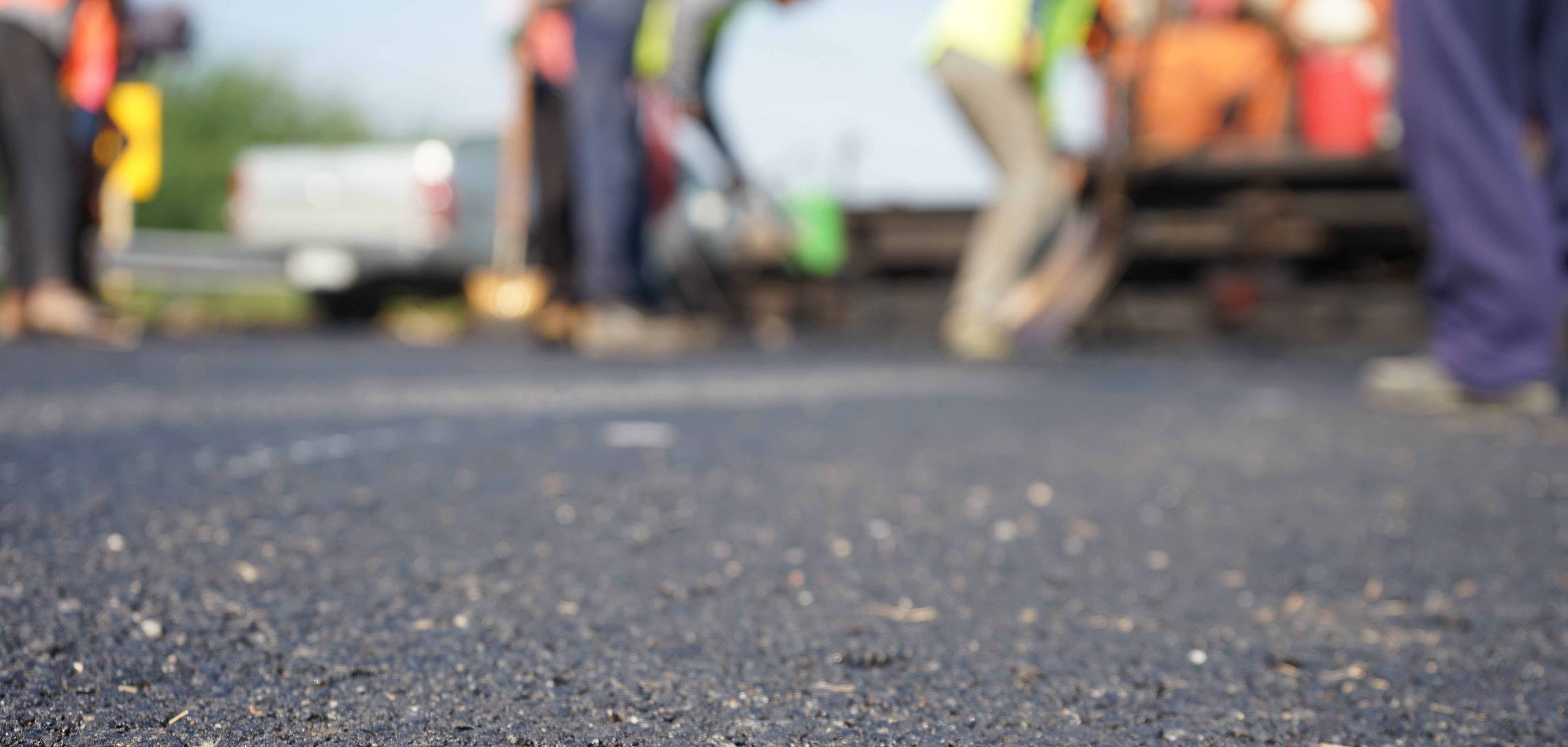 Construction workers on the asphalt road, blurred pictures