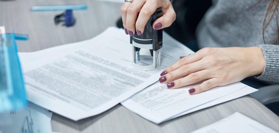 girl puts a stamp on documents in the office